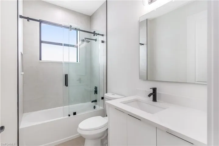 Bathroom with vanity and shower / bath combination with glass door