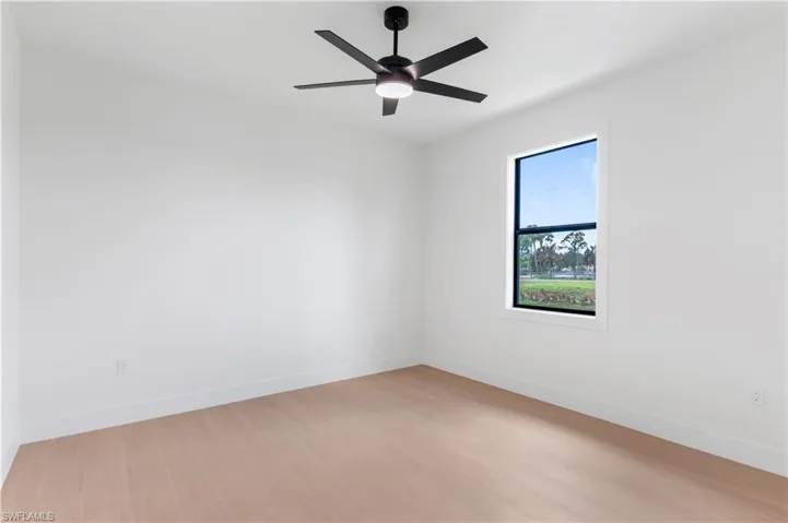 Bedroom with wood-look tile and ceiling fan
