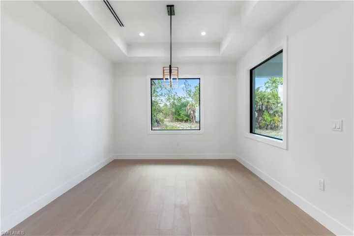 Dining room featuring a raised ceiling, wood-look tile, and recessed lighting