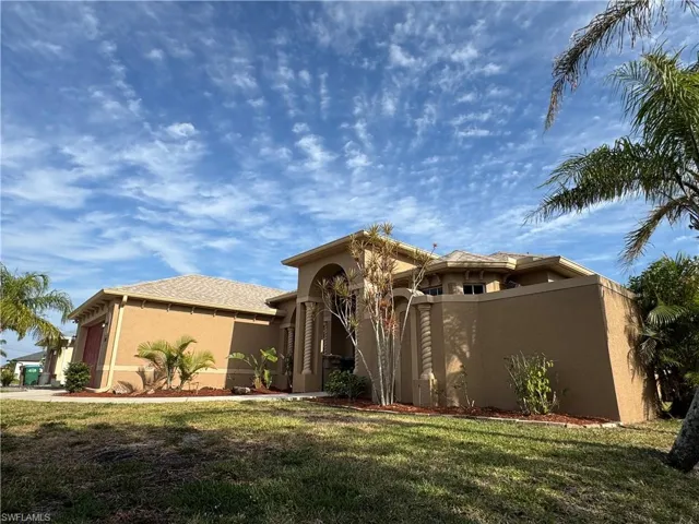 Mediterranean / spanish house with an attached garage, fence, a front yard, and stucco siding