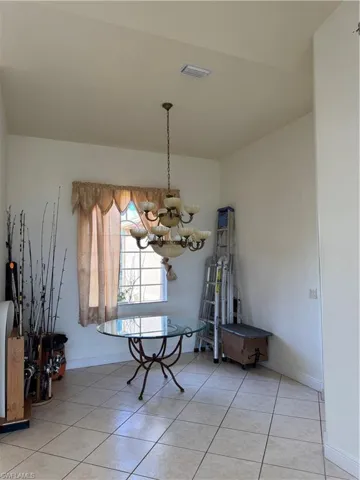 Dining space featuring baseboards, an inviting chandelier, visible vents, and light tile patterned floors