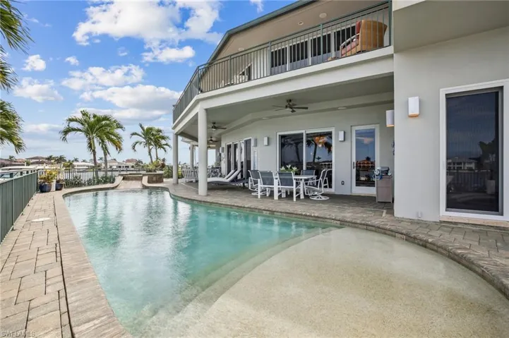 Outdoor pool featuring a patio area, a ceiling fan, a balcony, and outdoor dining area