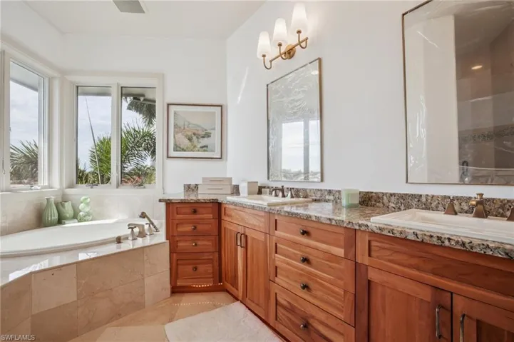 Bathroom featuring a garden tub, double vanity, and light tile patterned floors