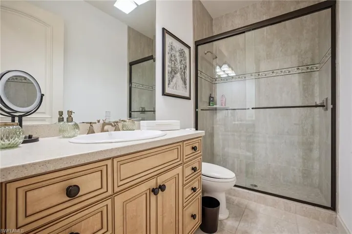 Bathroom with vanity, a shower stall, and light tile patterned flooring