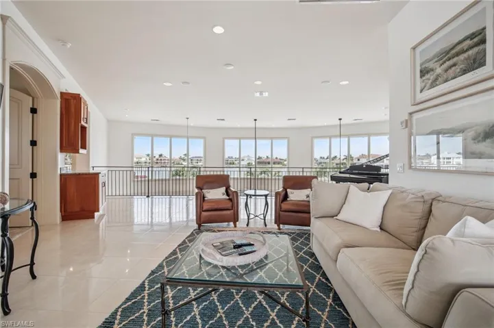 Living room with light tile patterned flooring, plenty of natural light, and recessed lighting