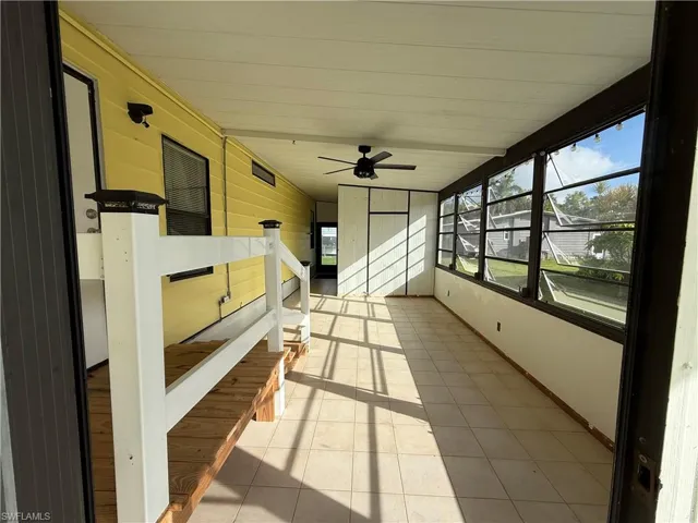 Unfurnished sunroom with ceiling fan