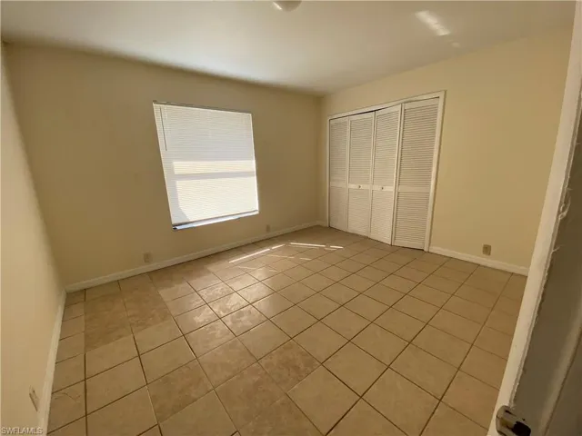 Unfurnished bedroom featuring light tile patterned flooring and a closet