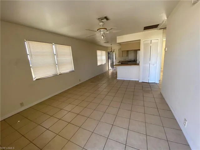 Unfurnished living room with light tile patterned floors and a ceiling fan