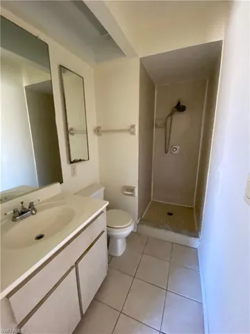 Bathroom with vanity, a stall shower, and light tile patterned flooring