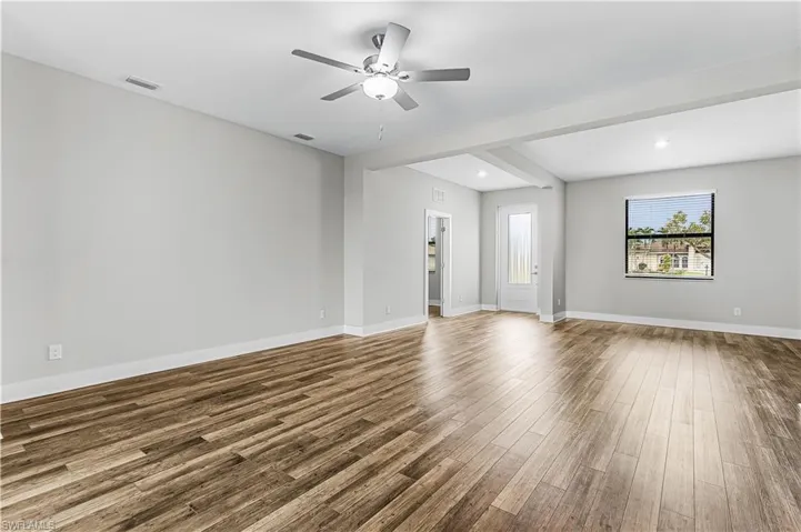 Unfurnished bedroom with dark wood-style floors and baseboards