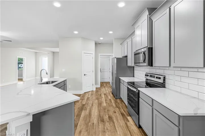 Spare room featuring dark wood-style flooring and baseboards
