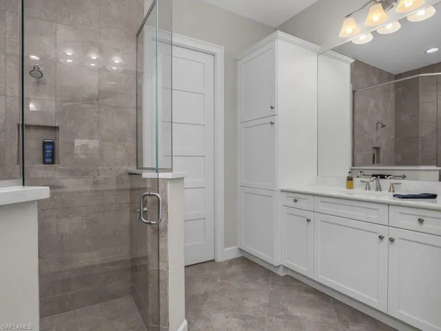 Master bath with dual vanities, quartz counter tops, frameless shower doors, walk in closet.