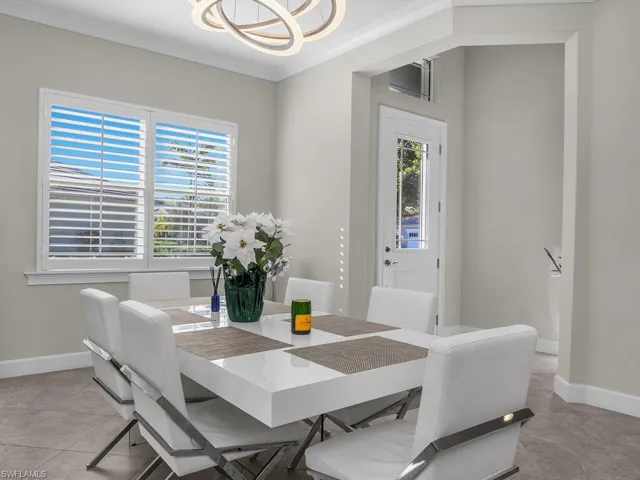 Dining room featuring crown molding and a modern light fixture, plantation shutters.