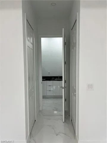 Hall featuring light tile patterned flooring and sink