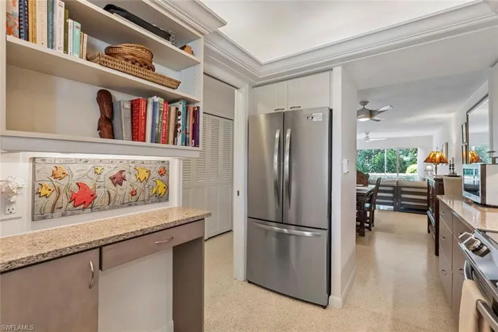 Kitchen featuring light stone countertops, stainless steel appliances, white cabinetry, and ceiling fan