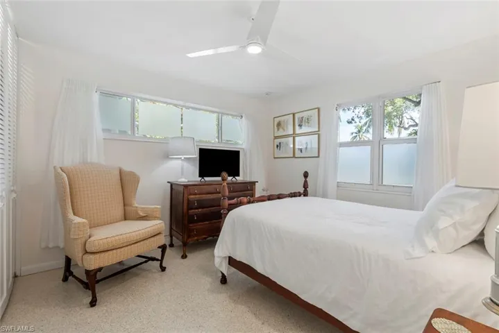 Bedroom with ceiling fan and multiple windows