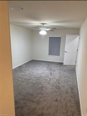 Unfurnished room featuring carpet and a ceiling fan