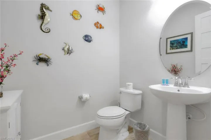 Half bathroom with toilet and wood finished floors