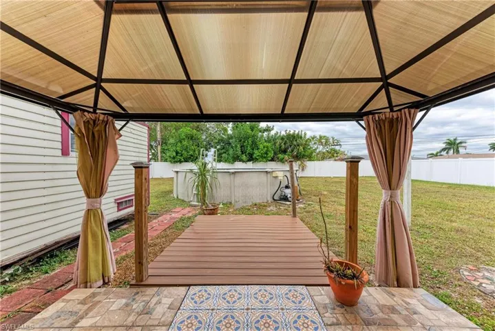 Fenced backyard featuring a patio and a gazebo