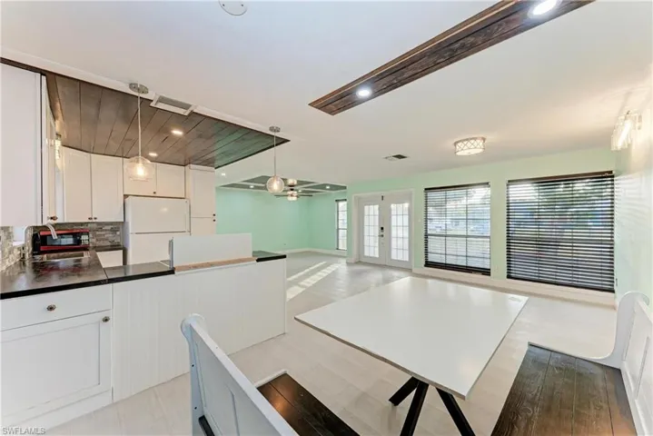 Kitchen featuring white cabinets, french doors, pendant lighting, freestanding refrigerator, and ceiling fan