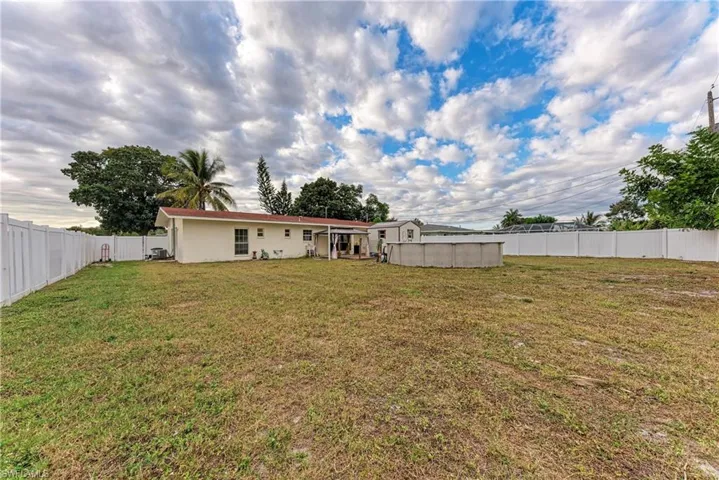 Back of property featuring a fenced backyard and a patio