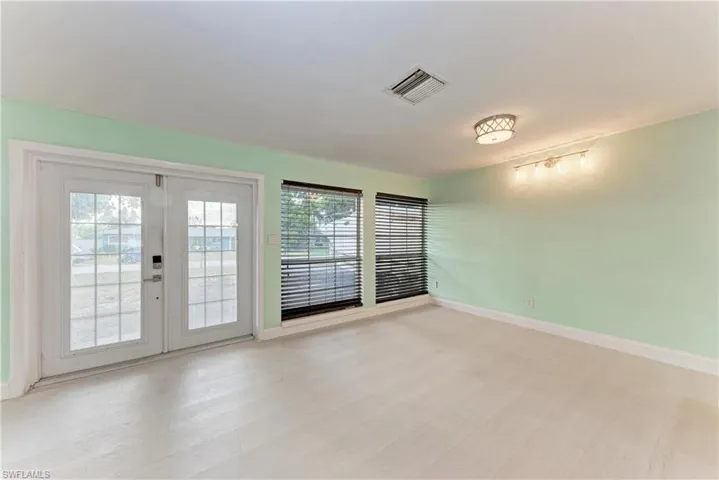 Empty room featuring french doors and light wood-style flooring