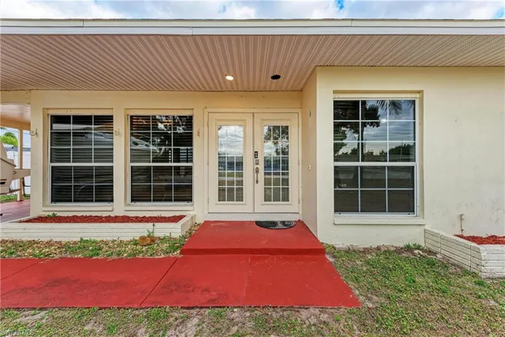 View of exterior entry with french doors and stucco siding