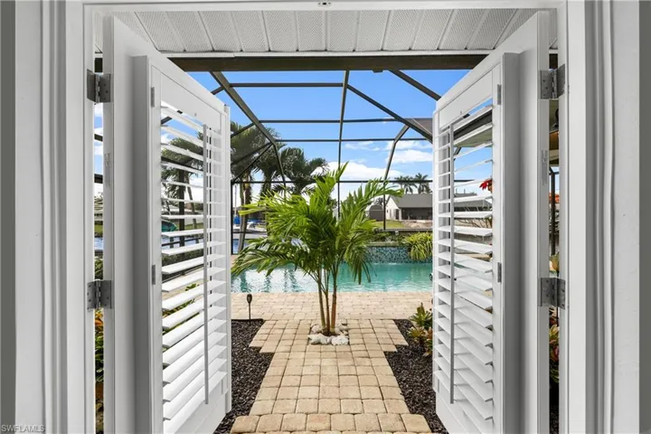 View of swimming pool featuring glass enclosure and a patio area