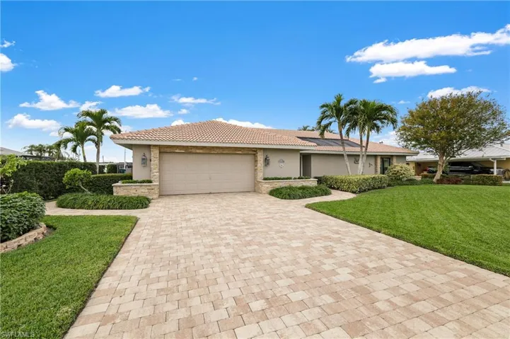 View of front facade featuring a front yard and a garage
