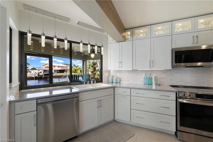 Kitchen featuring white cabinets, stainless steel appliances, and a water view