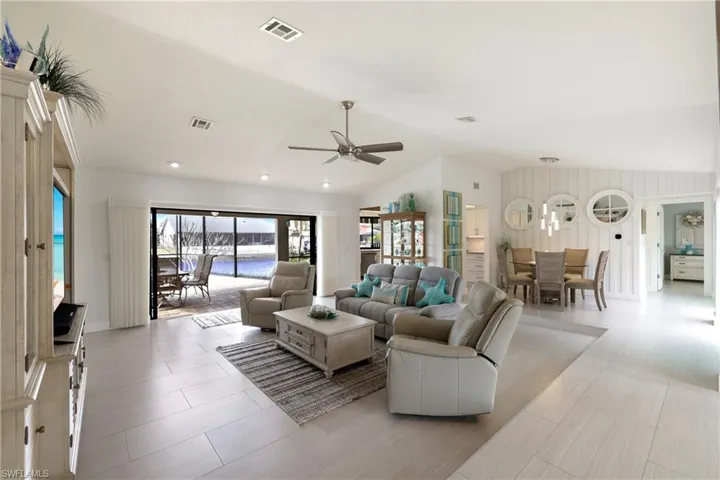 Living room featuring Hunter Douglas ceiling fan and vaulted ceiling