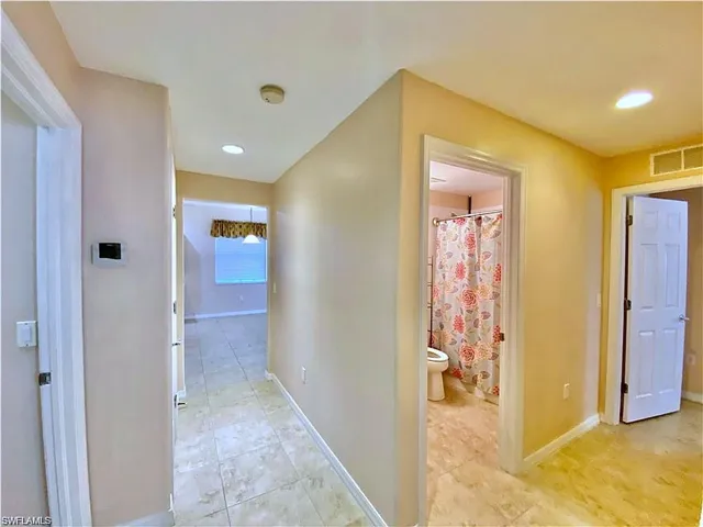 Hallway featuring tile flooring, recessed lighting, and six-panel interior doors