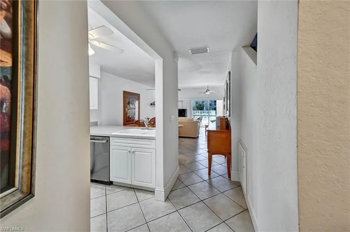 Tiled entryway featuring white walls and a clear sightline to the living area