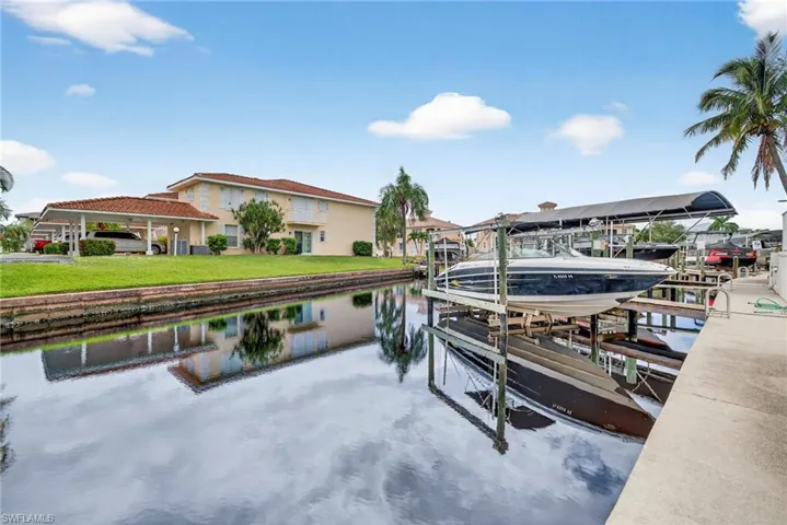 Dock featuring boat lift and a water view