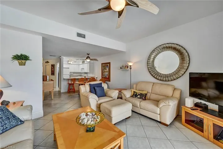 Spacious living area featuring tile flooring, a ceiling fan, and recessed lighting