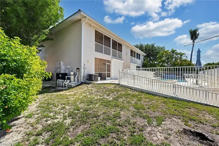 Stucco exterior featuring screened balconies on both levels