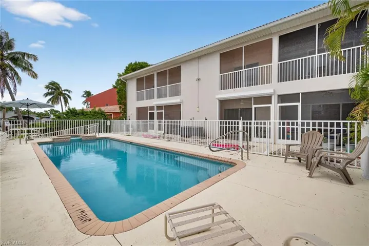 View of pool featuring a patio area, a sunroom, and a pool with connected hot tub