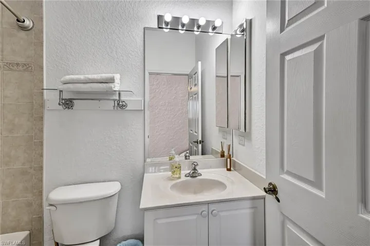Bathroom vanity with an integrated sink, white cabinetry, and a mirrored medicine cabinet
