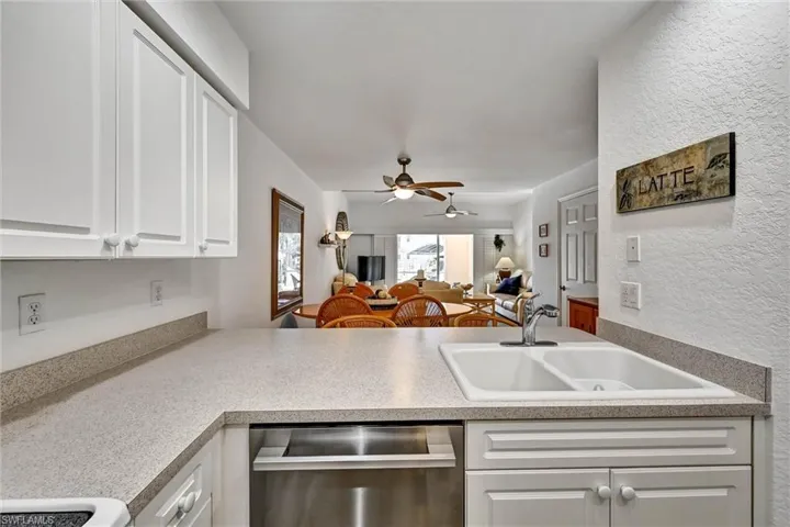 Kitchen with white cabinetry, a dual basin sink, and integrated stainless steel dishwasher