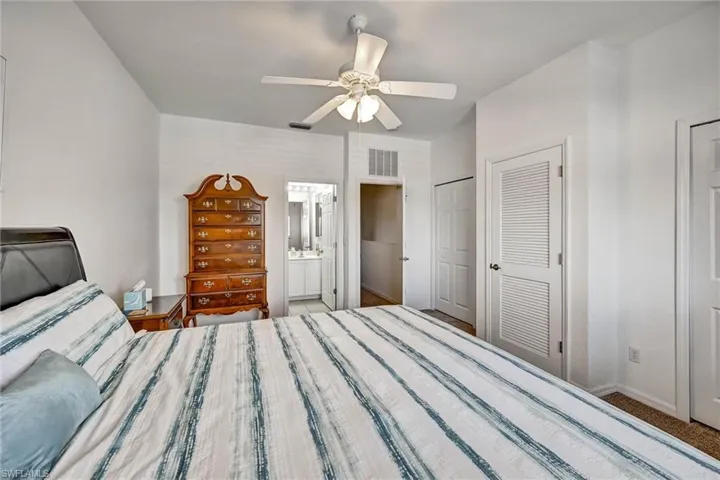 Bedroom featuring an angled ceiling, ceiling fan, and carpet flooring