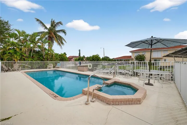 View of pool with a patio and a pool with connected hot tub