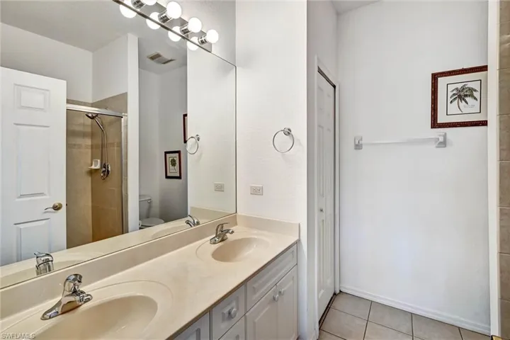 Double vanity with integrated sinks, chrome faucets, and white cabinetry