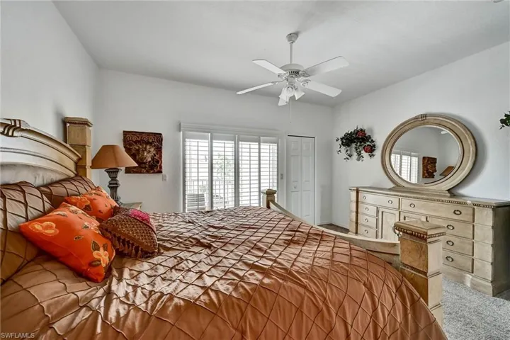 Vaulted ceiling featuring a ceiling fan, white bi-fold closet door, and window with plantation shutters