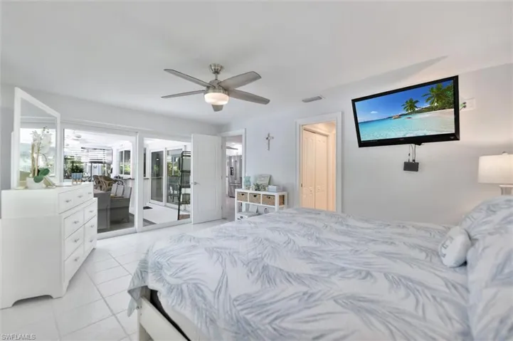 Bedroom with light tile patterned flooring, access to outside, ceiling fan, and a closet