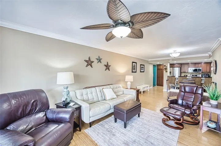 Living area featuring ornamental molding, light wood-type flooring, ceiling fan, baseboards, and recessed lighting