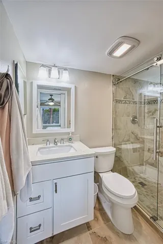 Bathroom with toilet, a shower stall, and vanity