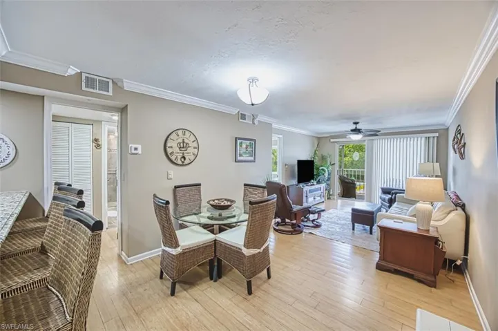Dining space featuring light wood-style flooring, ceiling fan, crown molding, and baseboards