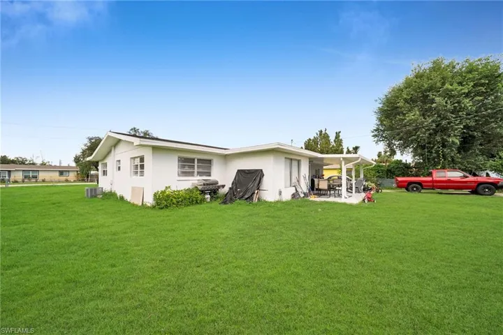 Back of property with a patio area, a yard, and cooling unit