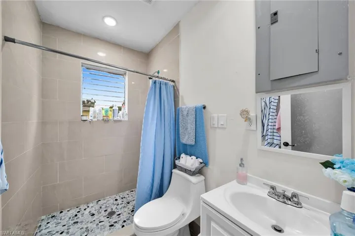 Bathroom with vanity, toilet, and curtained shower