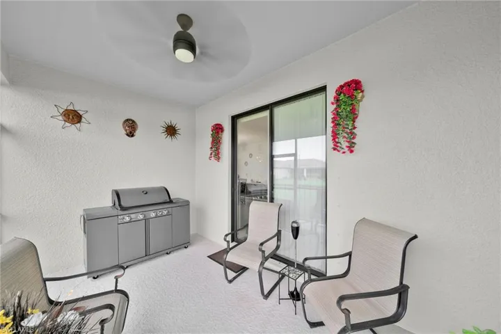Living area featuring light carpet and ceiling fan